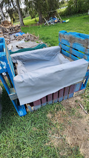 Pallet garden bed with first layer of landscaping fabric lining the bed.
