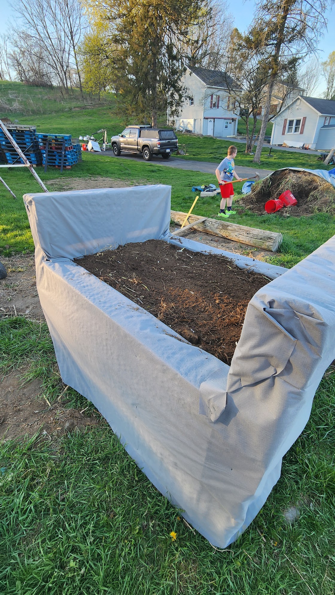 Garden bed wrapped in landscape fabric and filled with dirt.
